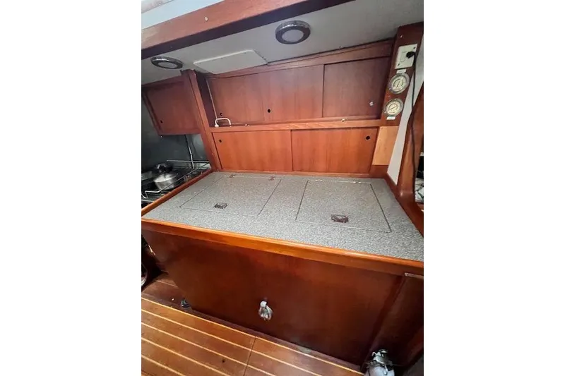 Slide: The Image of Wooden interior of 1985 Robert Clark Ketch, featuring a compact galley with storage. - 36