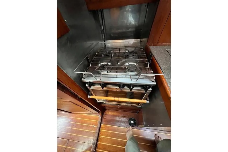 Slide: The Image of Galley stove in 1985 Robert Clark Ketch, featuring wooden flooring and compact design. - 37