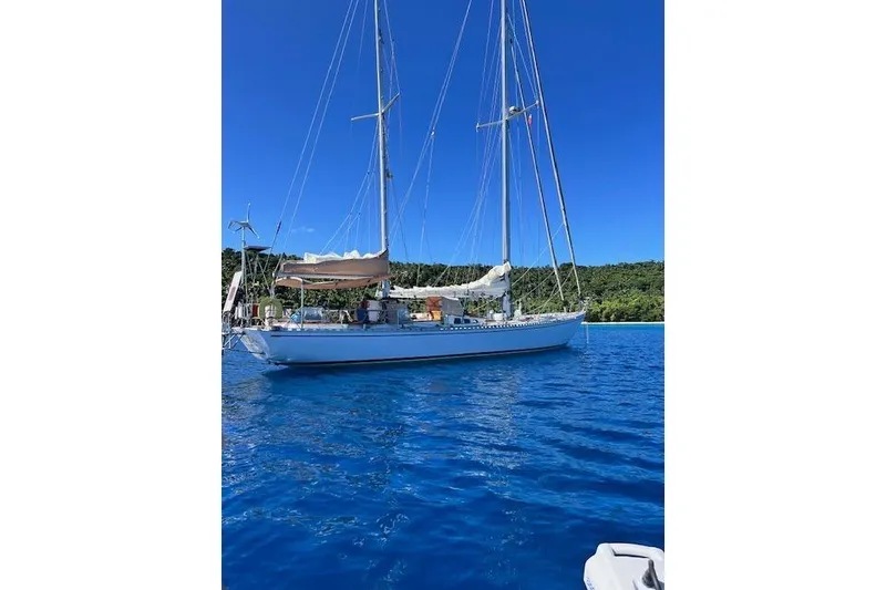 Slide: The Image of Robert Clark Ketch 1985 sailing on blue water near green coastline. - 4