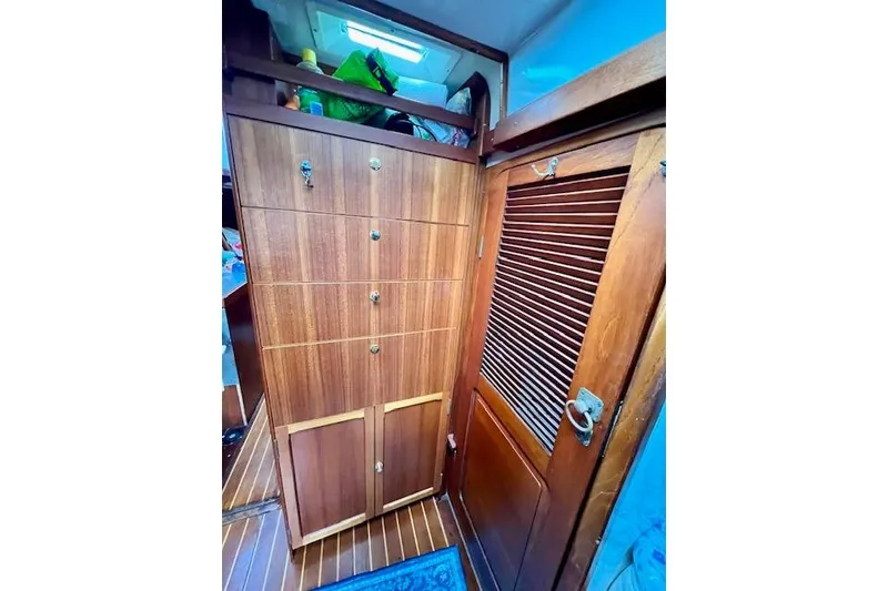 Slide: The Image of Wooden interior of 1985 Robert Clark Ketch, featuring cabinets and a louvered door. - 43