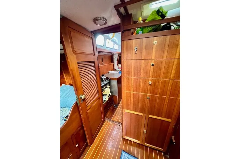 Slide: The Image of Interior of 1985 Robert Clark Ketch, featuring wooden cabinetry and cozy sleeping area. - 44