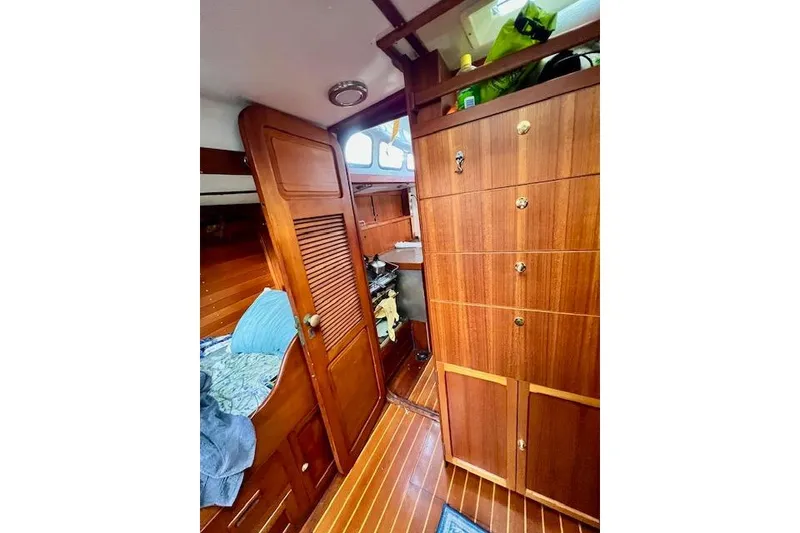 Slide: The Image of Interior of 1985 Robert Clark Ketch with wooden cabinetry and cozy sleeping area. - 45