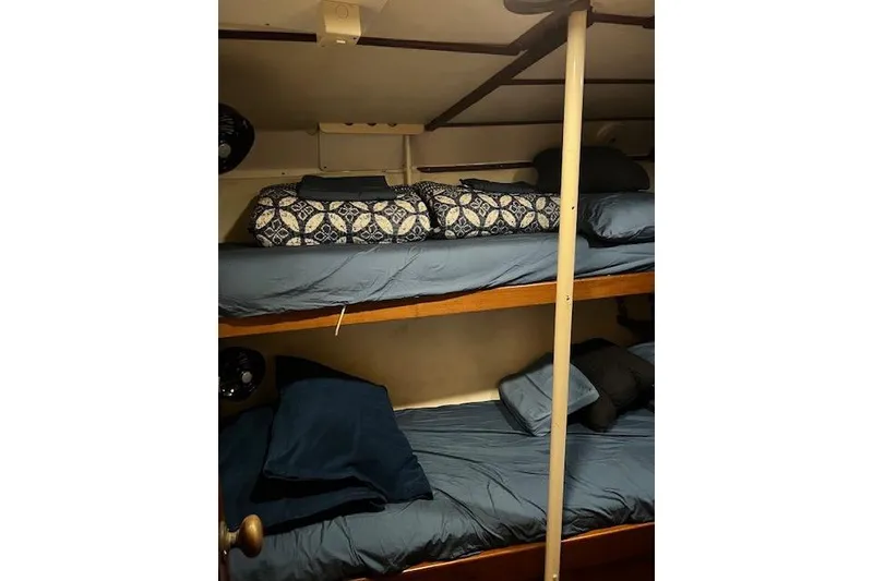 Slide: The Image of Bunk beds in a 1985 Robert Clark Ketch sailboat cabin with blue bedding. - 49