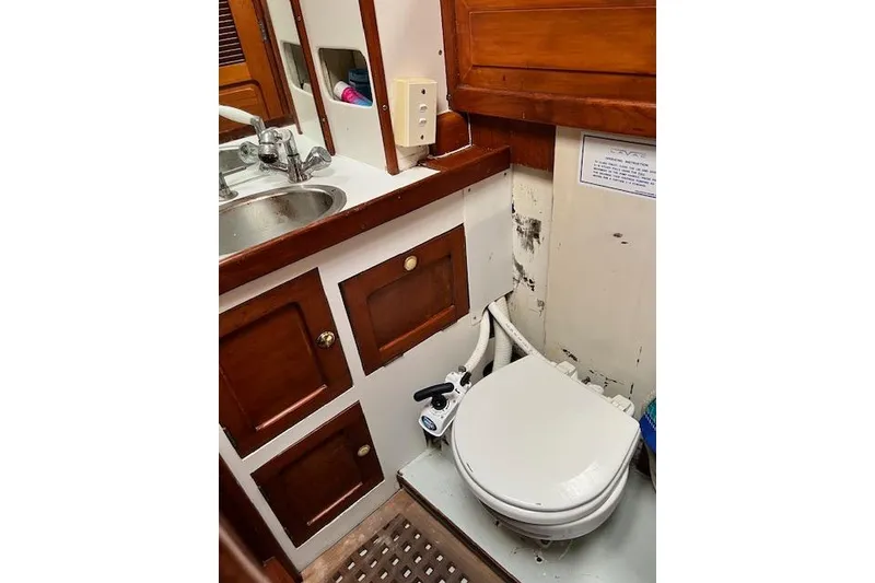 Slide: The Image of 1985 Robert Clark Ketch bathroom with wooden cabinets and marine toilet. - 52