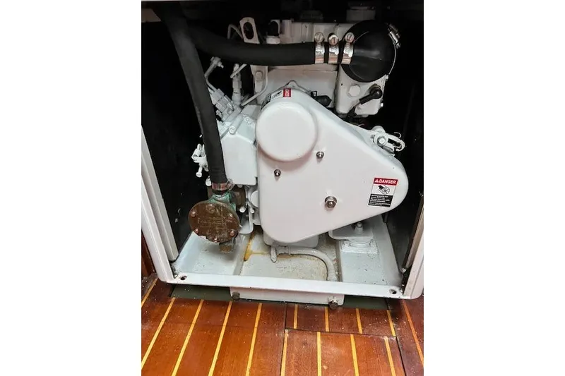 Slide: The Image of Engine compartment of 1985 Robert Clark Ketch with visible components and warning label. - 57