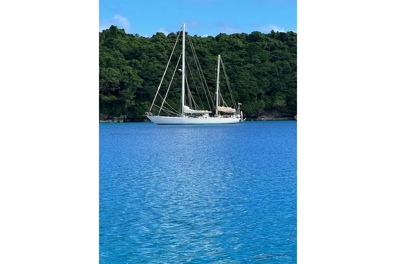 Slide: The Image of Sailboat on blue water near lush green island, Robert Clark Ketch, 1985. - 68