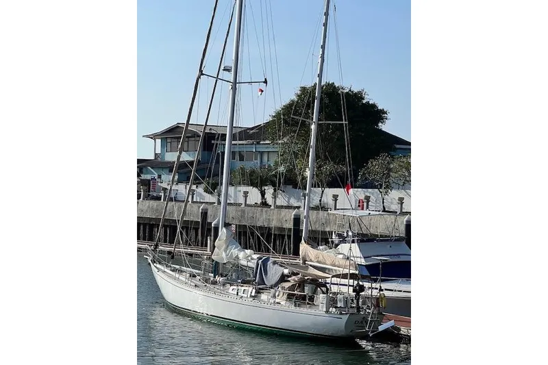 Slide: The Image of 1985 Robert Clark Ketch sailboat docked at marina, clear sky background. - 9