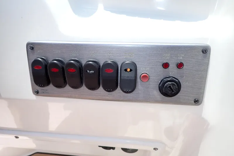 Slide: The Image of Control panel of 2021 NauticStar 223 DC boat with switches and indicators. - 19
