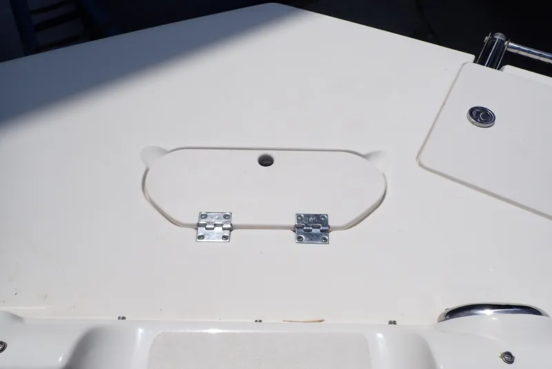 Slide: The Image of 2021 NauticStar 223 DC boat deck with storage compartment and hinges. - 22