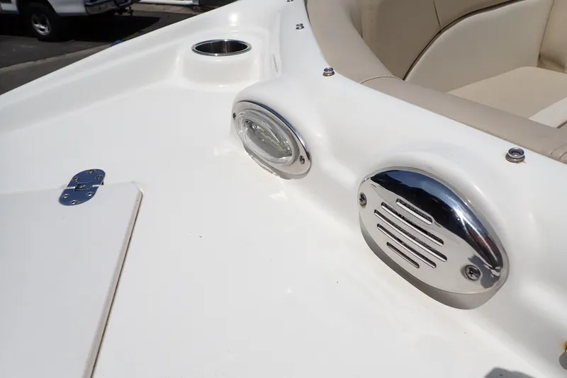 Slide: The Image of 2021 NauticStar 223 DC boat interior with chrome fixtures and beige seating. - 24