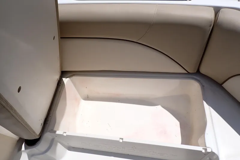Slide: The Image of 2021 NauticStar 223 DC boat storage compartment with beige seating. - 26