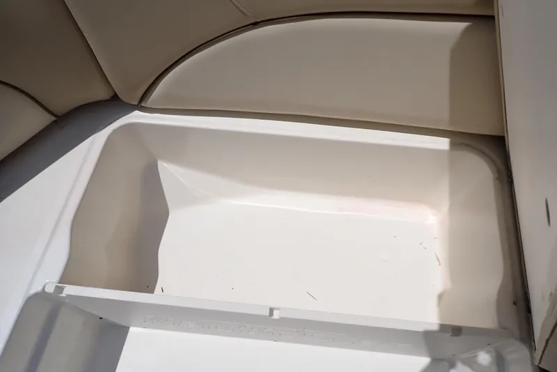 Slide: The Image of 2021 NauticStar 223 DC boat storage compartment with beige seating. - 29