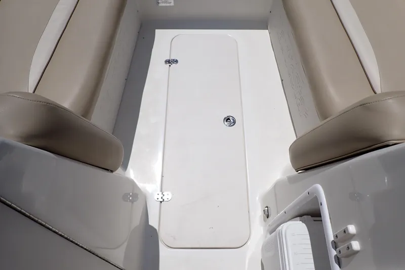 Slide: The Image of 2021 NauticStar 223 DC boat interior with beige seating and storage compartment. - 30