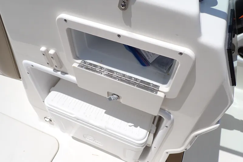 Slide: The Image of 2021 NauticStar 223 DC boat storage compartment with cooler and open hatch. - 33