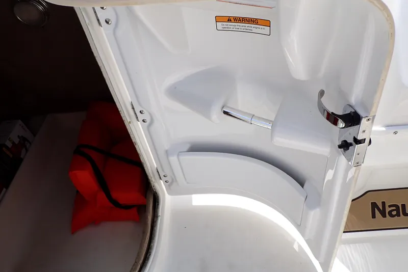 Slide: The Image of 2021 NauticStar 223 DC boat interior with storage compartment and safety equipment. - 36