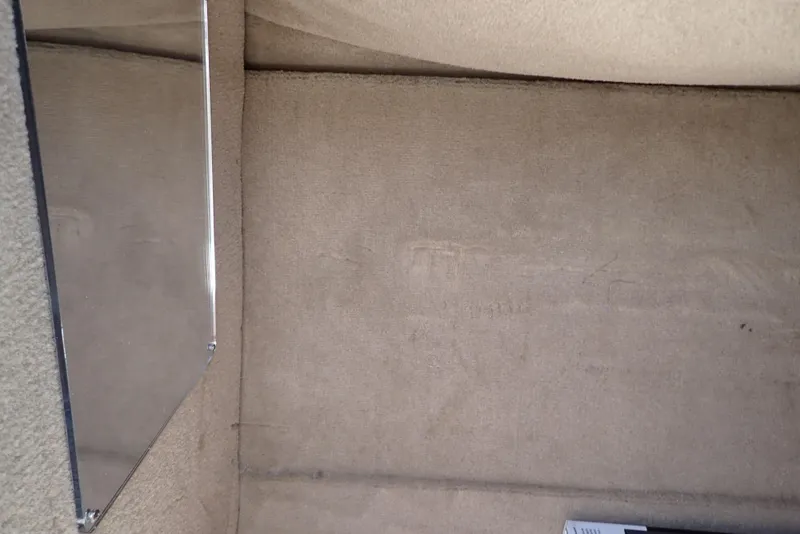 Slide: The Image of Interior view of a 2021 NauticStar 223 DC boat cabin with beige upholstery. - 38