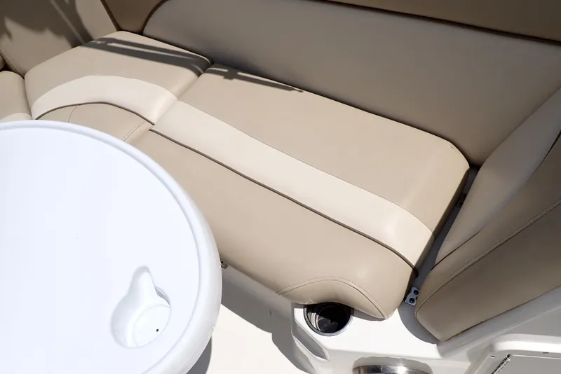 Slide: The Image of 2021 NauticStar 223 DC boat interior with beige seating and cup holder. - 49