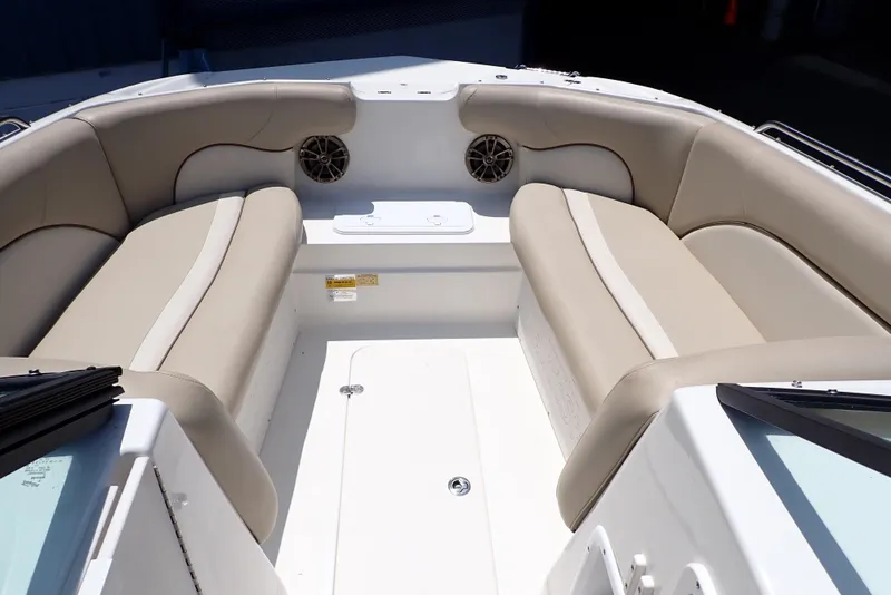 Slide: The Image of 2021 NauticStar 223 DC boat interior with beige seating and built-in speakers. - 7