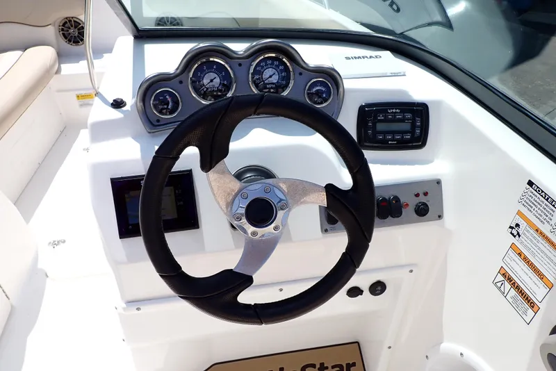 Slide: The Image of 2021 NauticStar 223 DC boat dashboard with steering wheel and instrument panel. - 9
