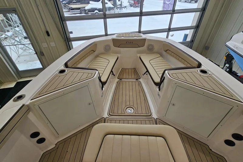 Slide: The Image of 2021 Yamaha Boats 210 FSH Sport interior with cushioned seating and storage compartments. - 11
