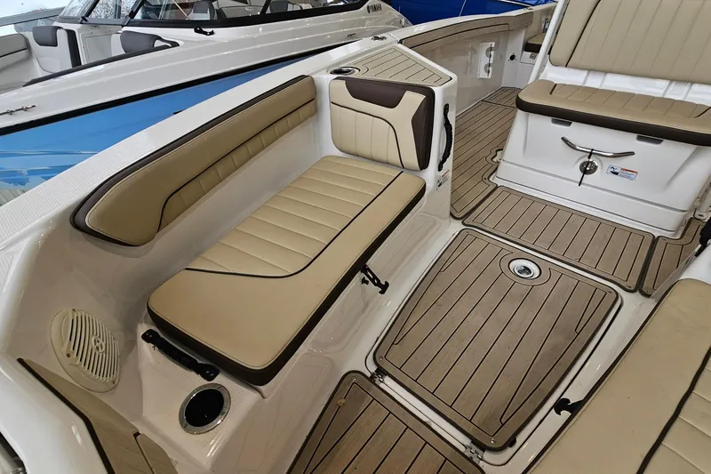 Slide: The Image of 2021 Yamaha Boats 210 FSH Sport interior with beige seating and wood-style flooring. - 14
