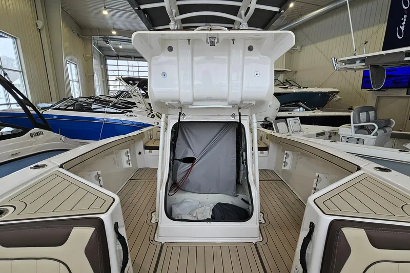 Slide: The Image of 2021 Yamaha Boats 210 FSH Sport interior with open storage compartment in showroom. - 17