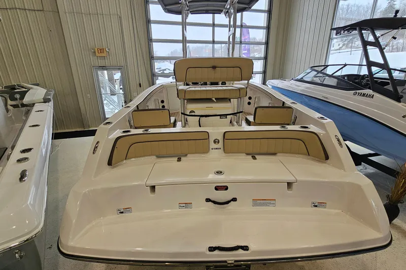 Slide: The Image of 2021 Yamaha Boats 210 FSH Sport in showroom, featuring spacious seating and sleek design. - 4