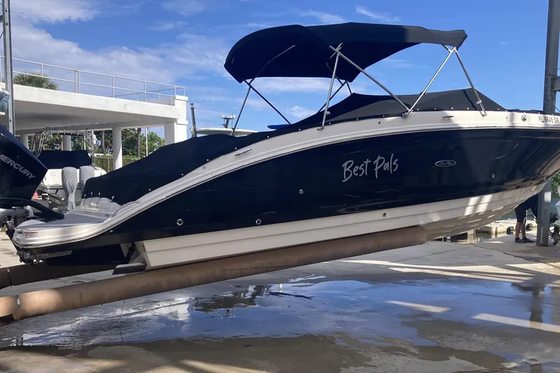 Slide: The Image of 2020 Sea Ray SDX 270 Outboard boat named "Best Pals" on a lift, under blue sky. - 10