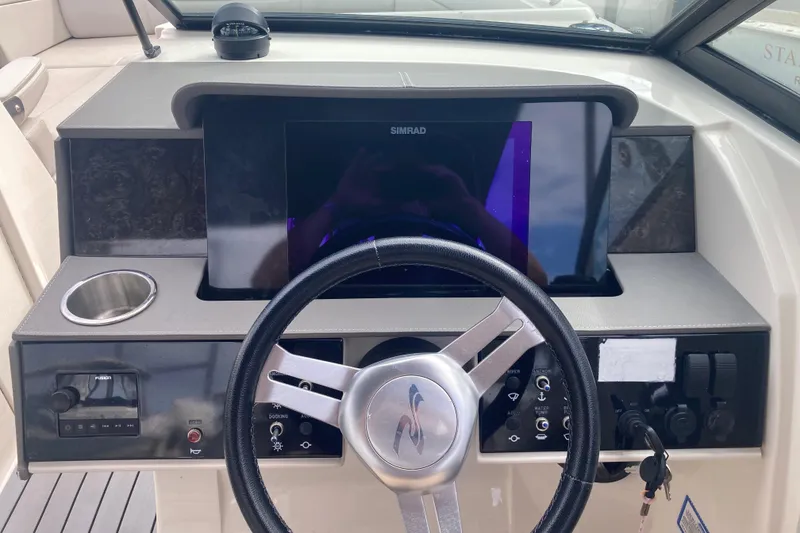 Slide: The Image of 2020 Sea Ray SDX 270 Outboard dashboard with steering wheel and navigation display. - 21