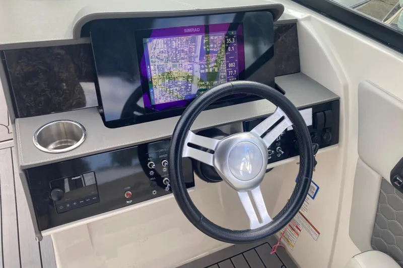 Slide: The Image of 2020 Sea Ray SDX 270 Outboard dashboard with steering wheel and navigation display. - 24