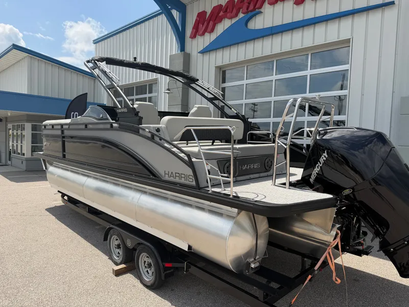 Slide: The Image of Harris Solstice DC 250 pontoon boat, 2026 model, on trailer outside a building. - 2