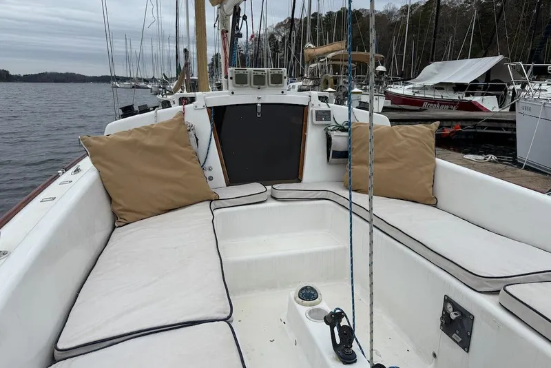Slide: The Image of 2008 e Sailing Yachts e33 sailboat with cushioned seating in a marina setting. - 8