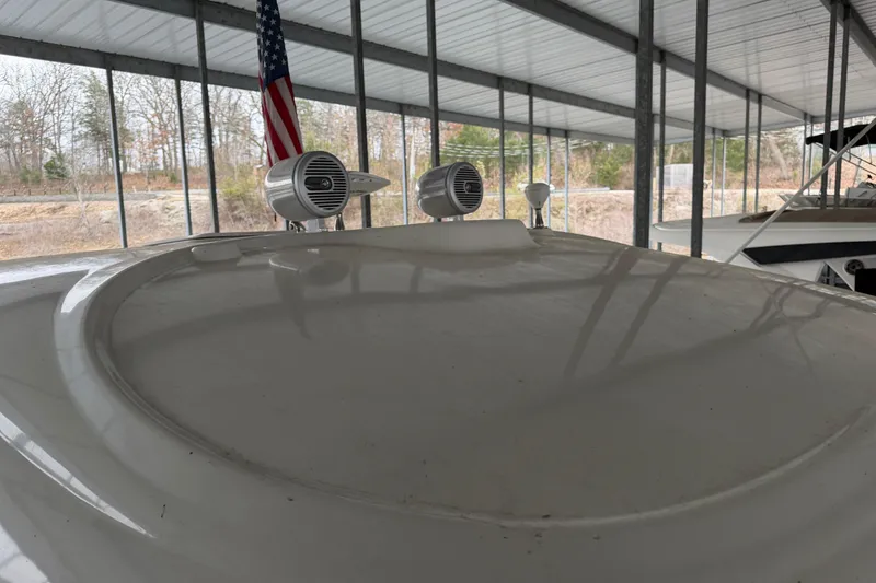 Slide: The Image of 2006 Sea Ray 40 Sundancer boat under covered dock with speakers and American flag. - 11