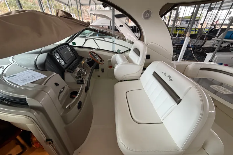 Slide: The Image of 2006 Sea Ray 40 Sundancer cockpit with white seating and modern dashboard controls. - 20