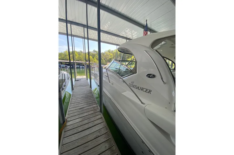 Slide: The Image of 2006 Sea Ray 40 Sundancer docked under a covered marina with wooden walkway. - 4