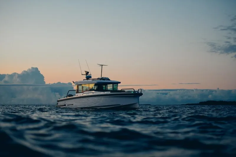 Slide: The Image of 2025 Axopar 37XC CROSS CABIN BRABUS Trim boat on calm water at sunset. - 10