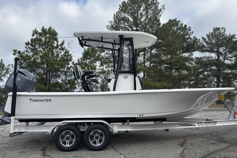 Slide: The Image of 2026 Tidewater 2210 Carolina Bay boat on trailer, parked outdoors with trees in background. - 3