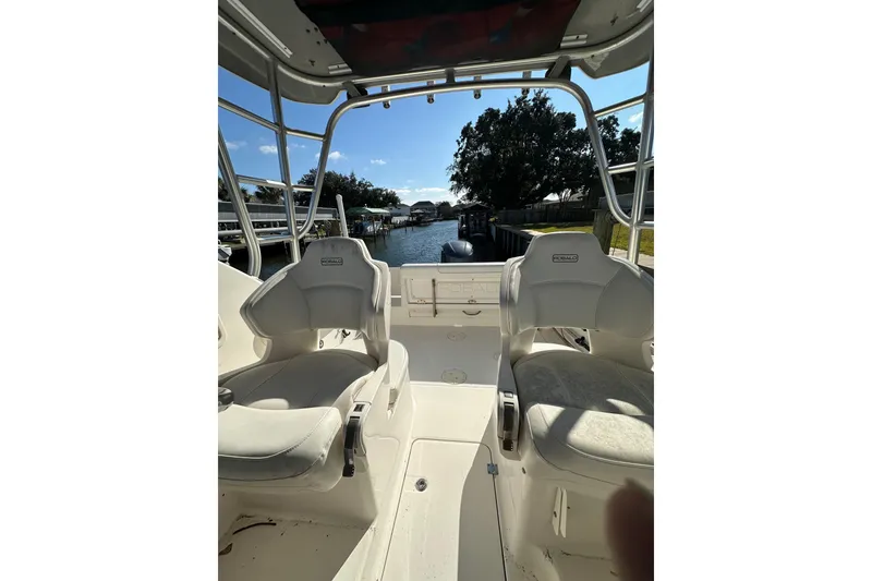 Slide: The Image of 2011 Robalo R245 Walkaround boat interior with seating, overlooking a serene waterway. - 10