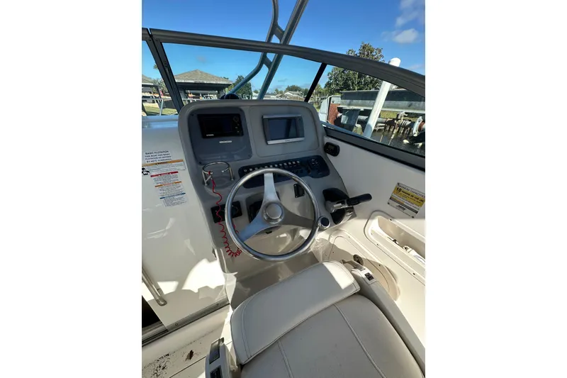 Slide: The Image of 2011 Robalo R245 Walkaround boat helm with steering wheel and control panel. - 11