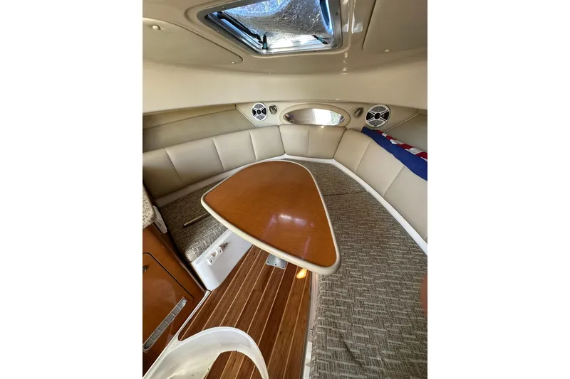 Slide: The Image of 2011 Robalo R245 Walkaround cabin interior with seating and wooden table. - 13