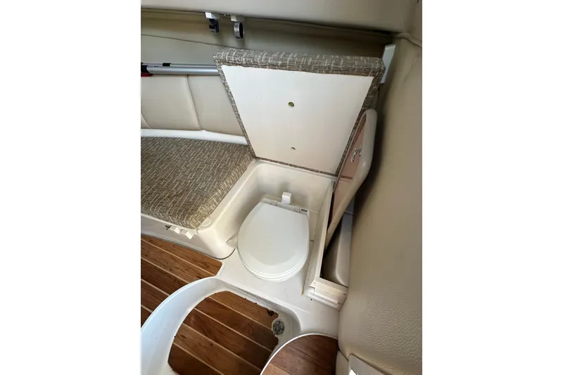 Slide: The Image of 2011 Robalo R245 Walkaround boat interior with compact toilet and seating area. - 14
