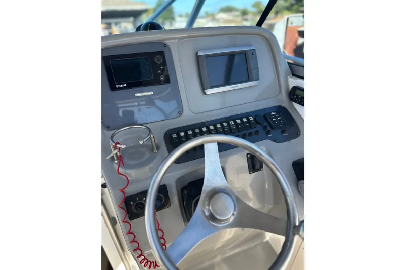 Slide: The Image of 2011 Robalo R245 Walkaround boat dashboard with steering wheel and navigation controls. - 16