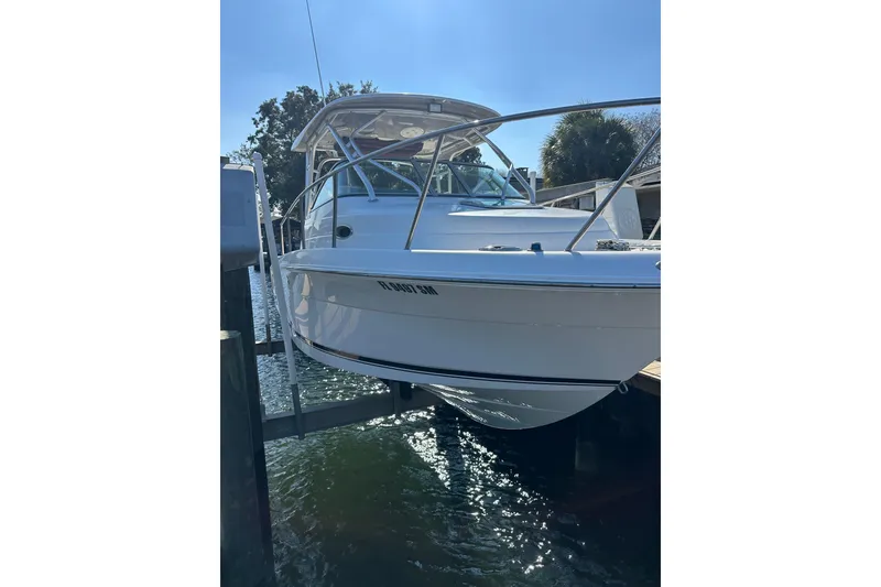 Slide: The Image of 2011 Robalo R245 Walkaround boat docked in sunny marina. - 3