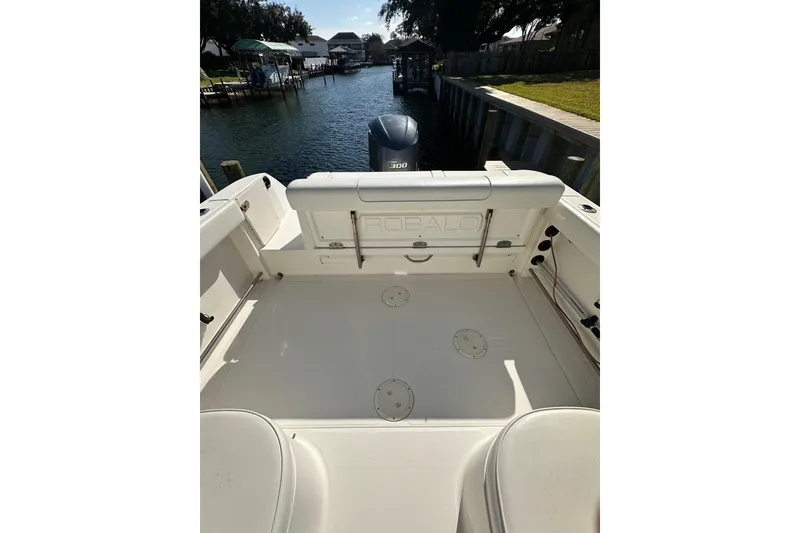 Slide: The Image of 2011 Robalo R245 Walkaround boat interior with Yamaha engine, docked by a canal. - 4