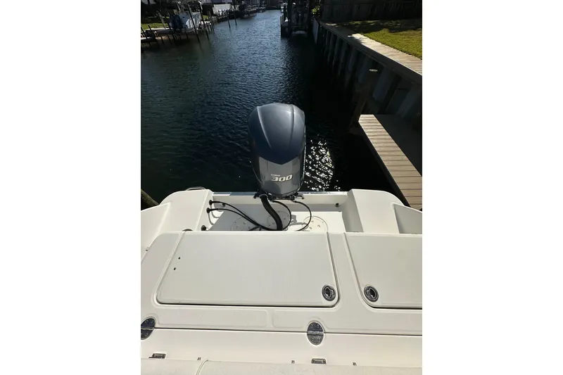 Slide: The Image of 2011 Robalo R245 Walkaround boat with powerful outboard motor, docked by a serene waterway. - 6