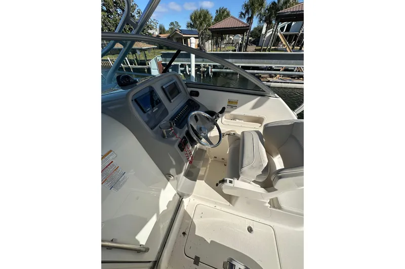 Slide: The Image of 2011 Robalo R245 Walkaround boat cockpit with steering wheel and control panel. - 7