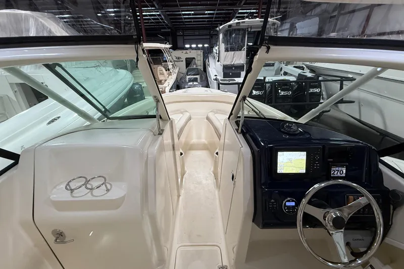 Slide: The Image of 2014 Pursuit DC 265 Dual Console boat interior, showcasing spacious deck and seating area. - 12