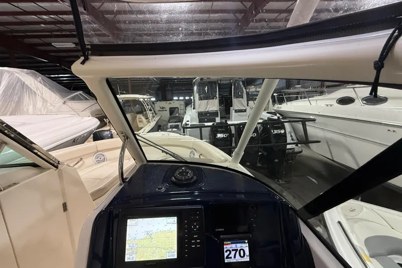 Slide: The Image of 2014 Pursuit DC 265 Dual Console boat interior with white seating and "Nautica" pillow. - 14