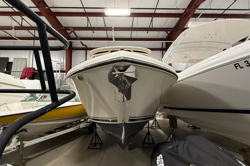Slide: The Image of 2014 Pursuit DC 265 Dual Console boat in storage with Yamaha and Mercury engines. - 2