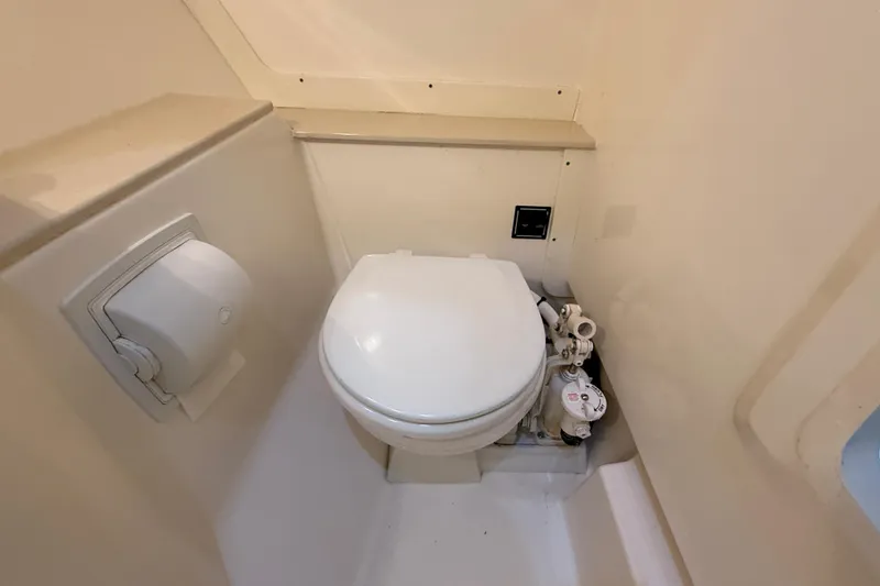 Slide: The Image of 2014 Pursuit DC 265 Dual Console boat interior with white seating and storage compartments. - 23